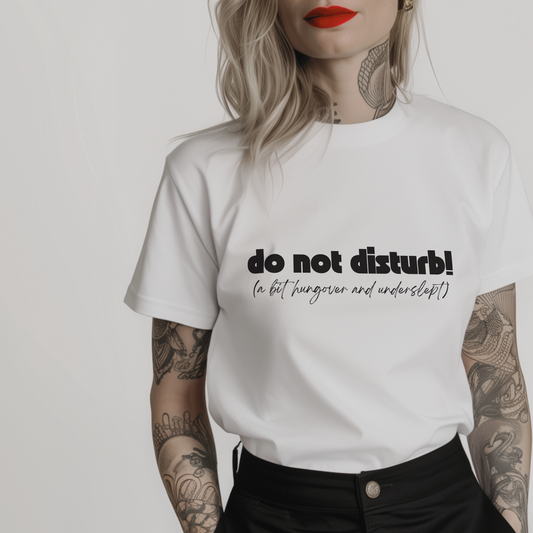 Women’s minimalist t-shirt with the quote 'do not disturb! (a bit hungover and underslept)' in a simple design and white color.